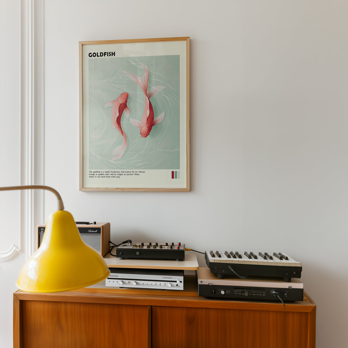 Pink goldfish pair on mint water print in an oak frame above a teak sideboard with vintage hi-fi