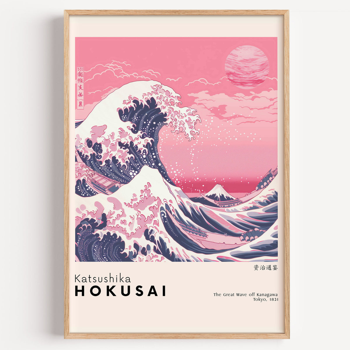 Pink Great Wave off Kanagawa print in a light oak frame on a plain white wall