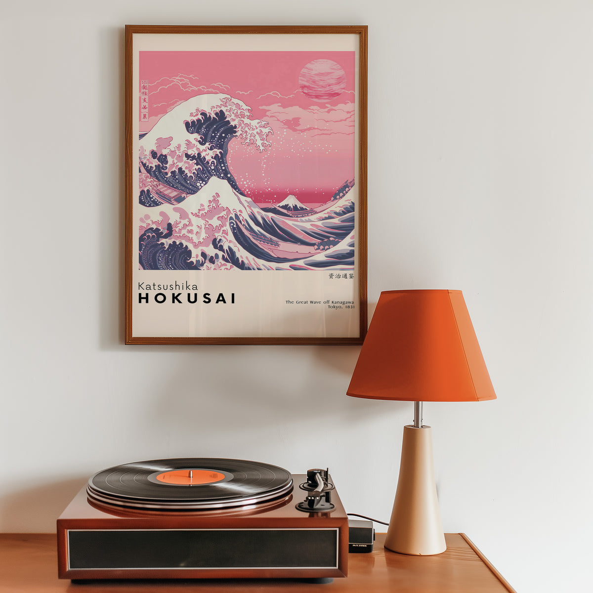 Pink Great Wave off Kanagawa print in a walnut frame above a sideboard with a record player