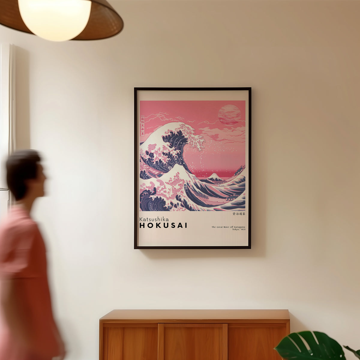 Pink Great Wave off Kanagawa print in a black frame in a hallway under a rattan pendant