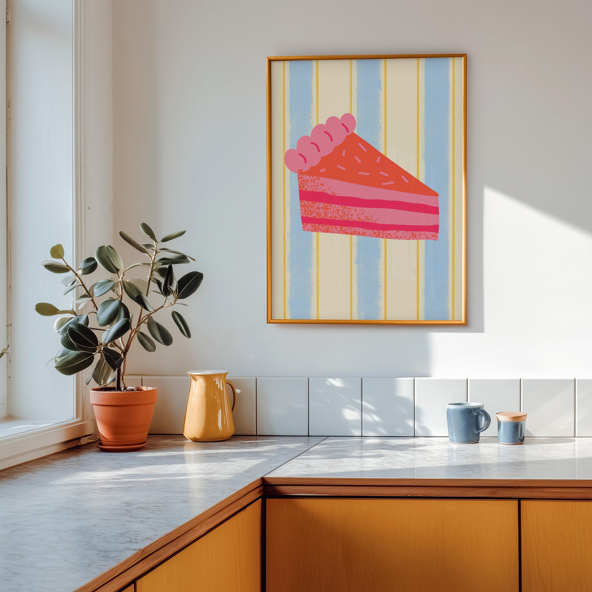 Pink layer cake print in a gold frame above a marble counter with a yellow jug