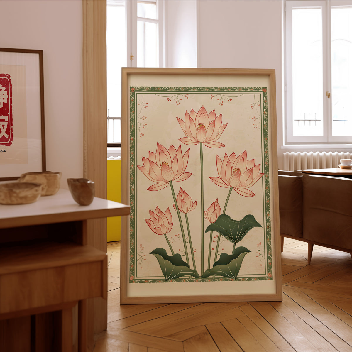 Five pink lotus flowers print in an oak frame on the parquet floor of a sunlit living room