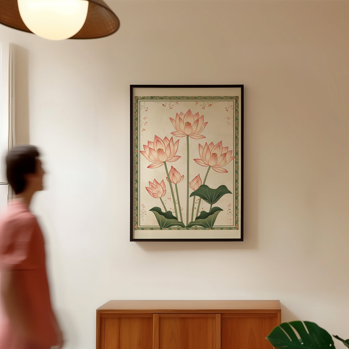 Five pink lotus flowers print in a black frame in a hallway under a rattan pendant