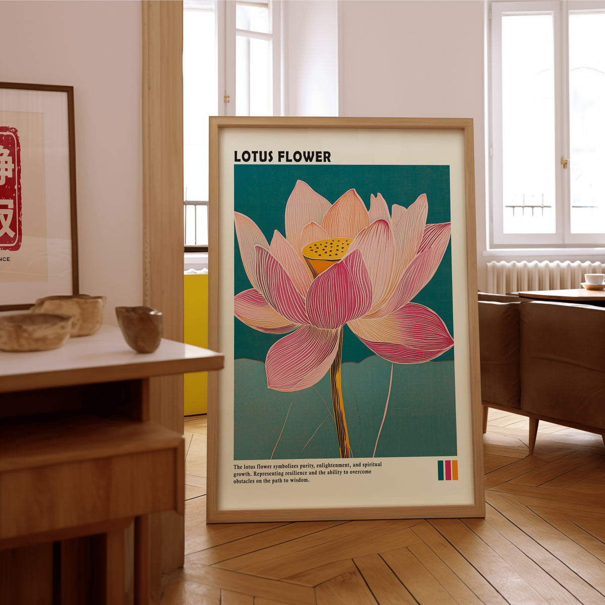 Single pink lotus on teal print in an oak frame on the parquet floor of a sunlit living room