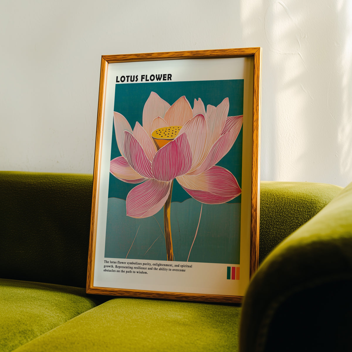 Single pink lotus on teal print in an oak frame propped on a green velvet sofa