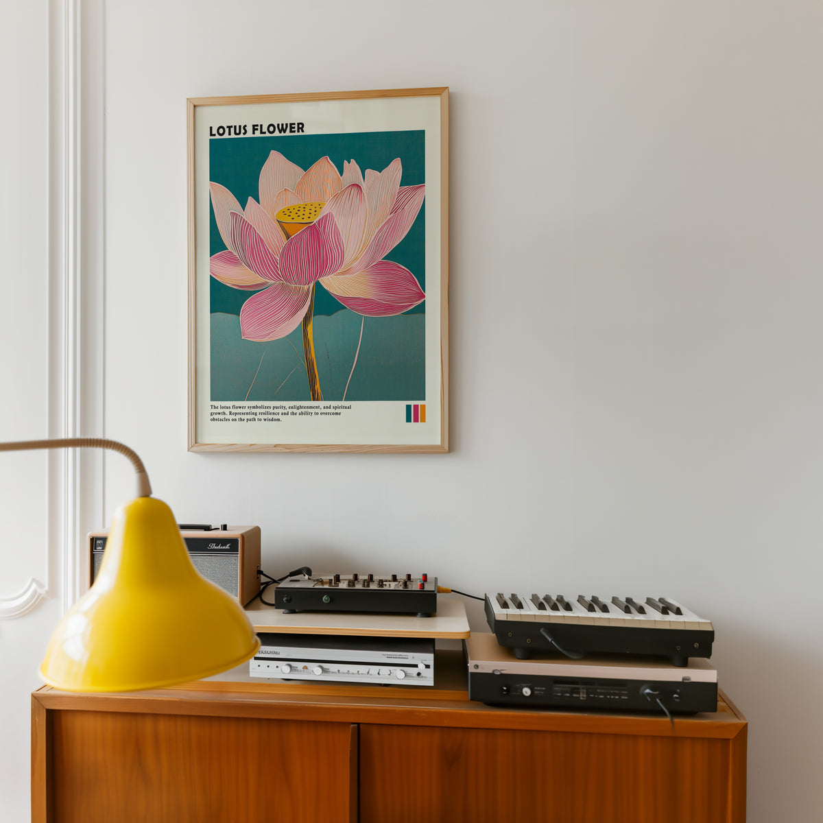Single pink lotus on teal print in an oak frame above a teak sideboard with vintage hi-fi