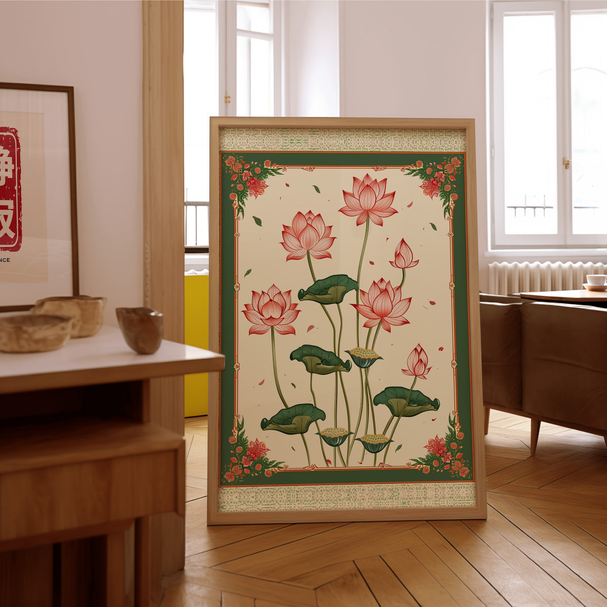 Pink lotus with green ornamental border print in an oak frame on the parquet floor of a sunlit living room