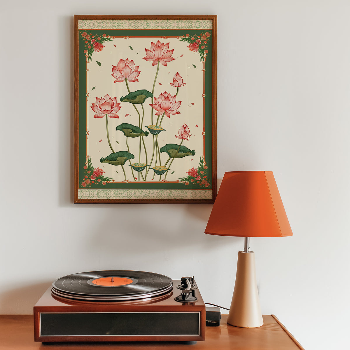 Pink lotus with green ornamental border print in a walnut frame above a sideboard with a record player