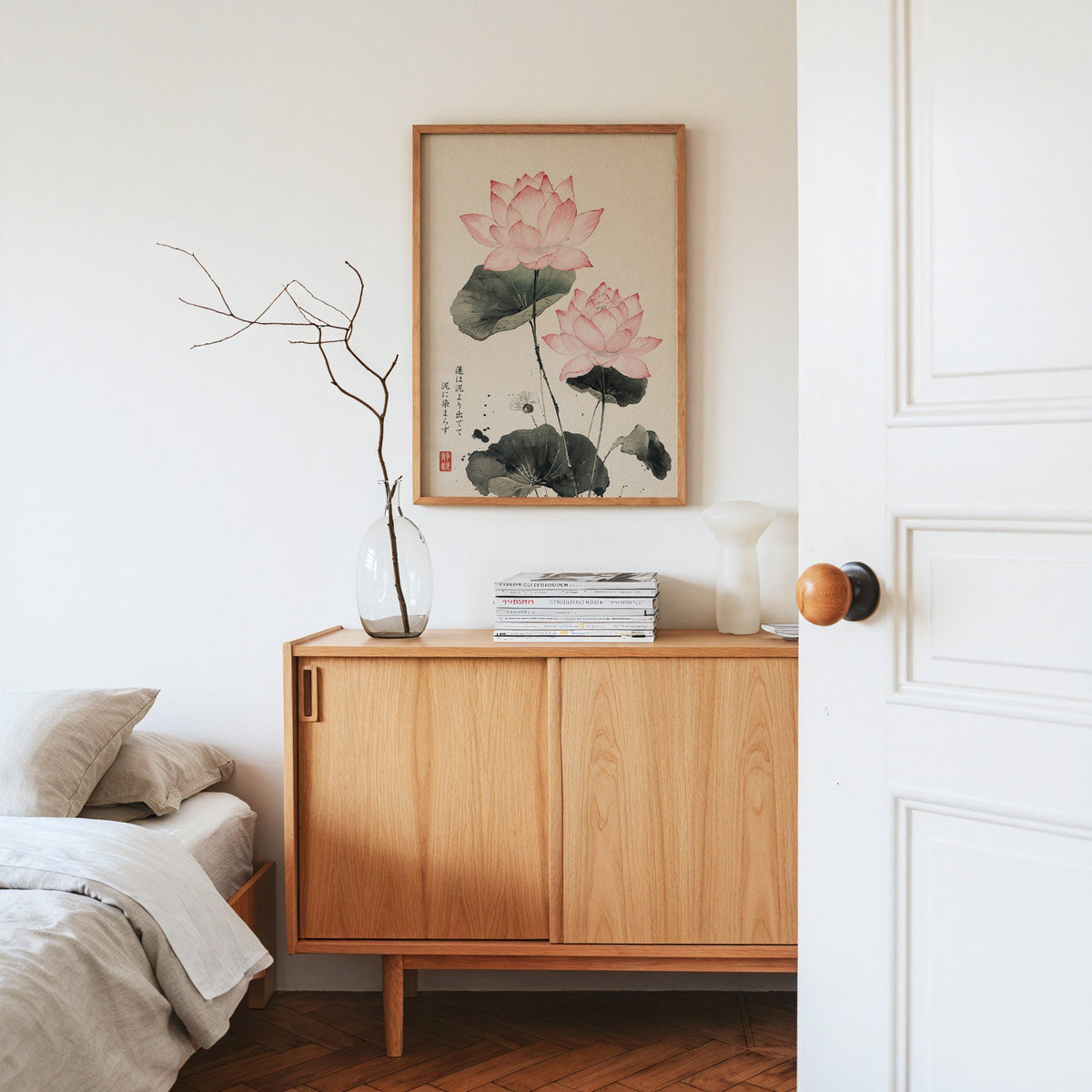 pink lotus ink painting with proverb print in an oak frame above an oak sideboard in a bedroom with linen bedding