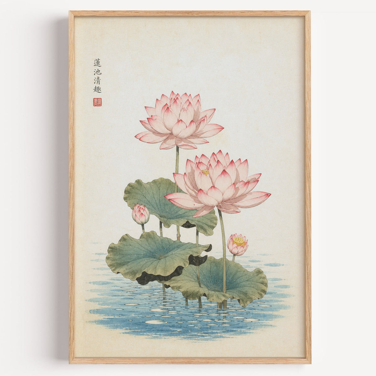 pink lotus pond print in a light oak frame on a plain white wall