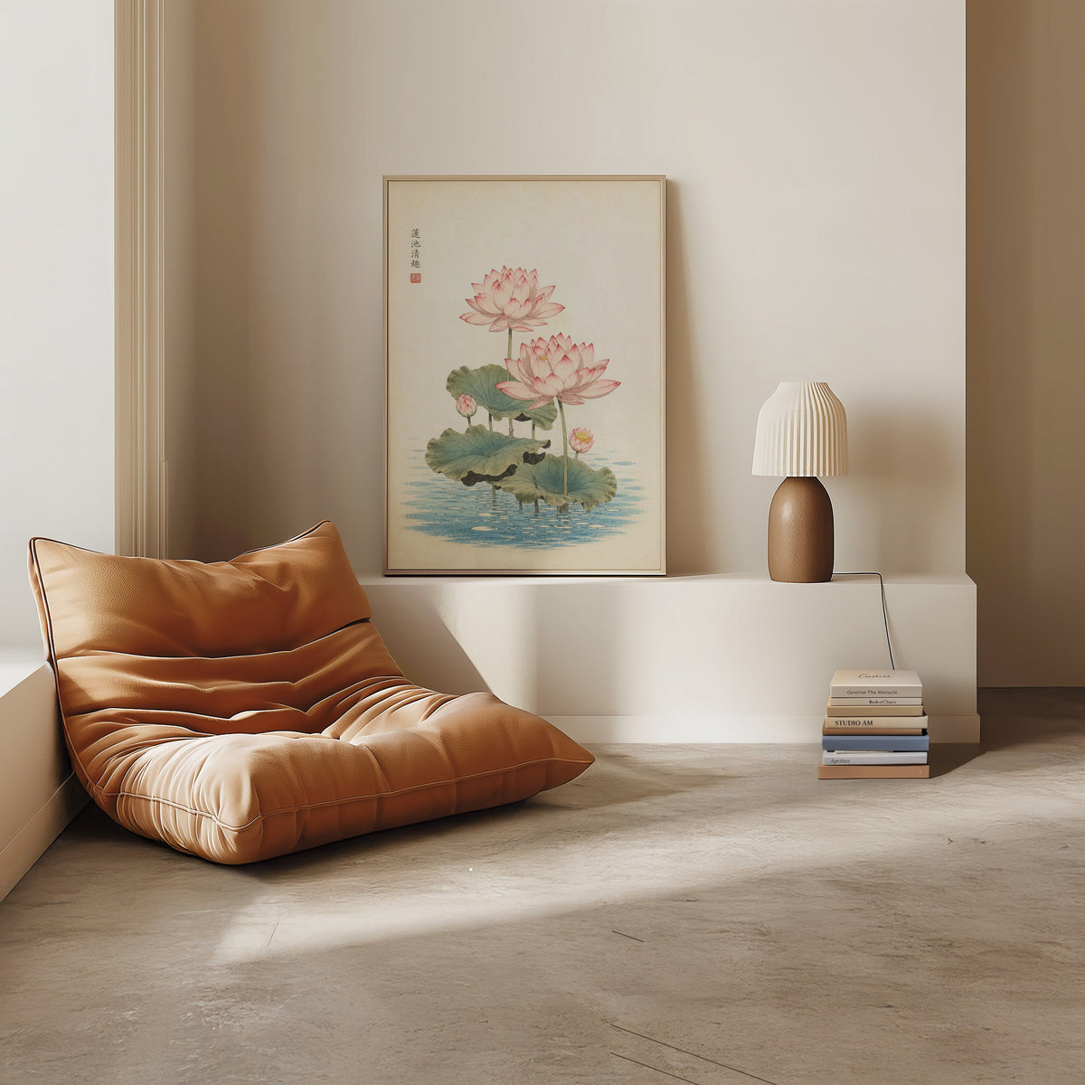 pink lotus pond print in a light oak frame on a white ledge by a tan leather floor chair