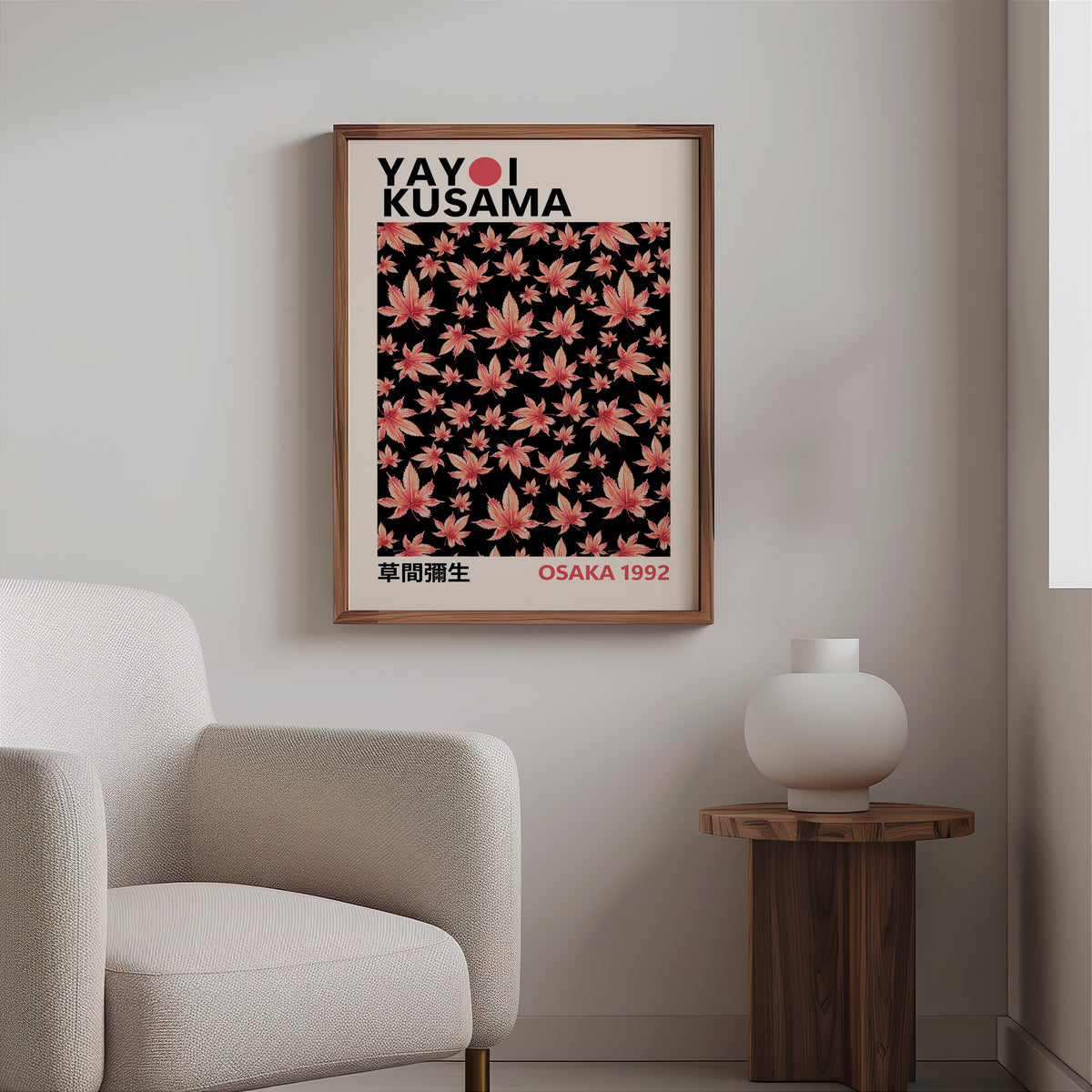 Yayoi Kusama inspired pink maple leaves on black print in a walnut frame above a boucle armchair