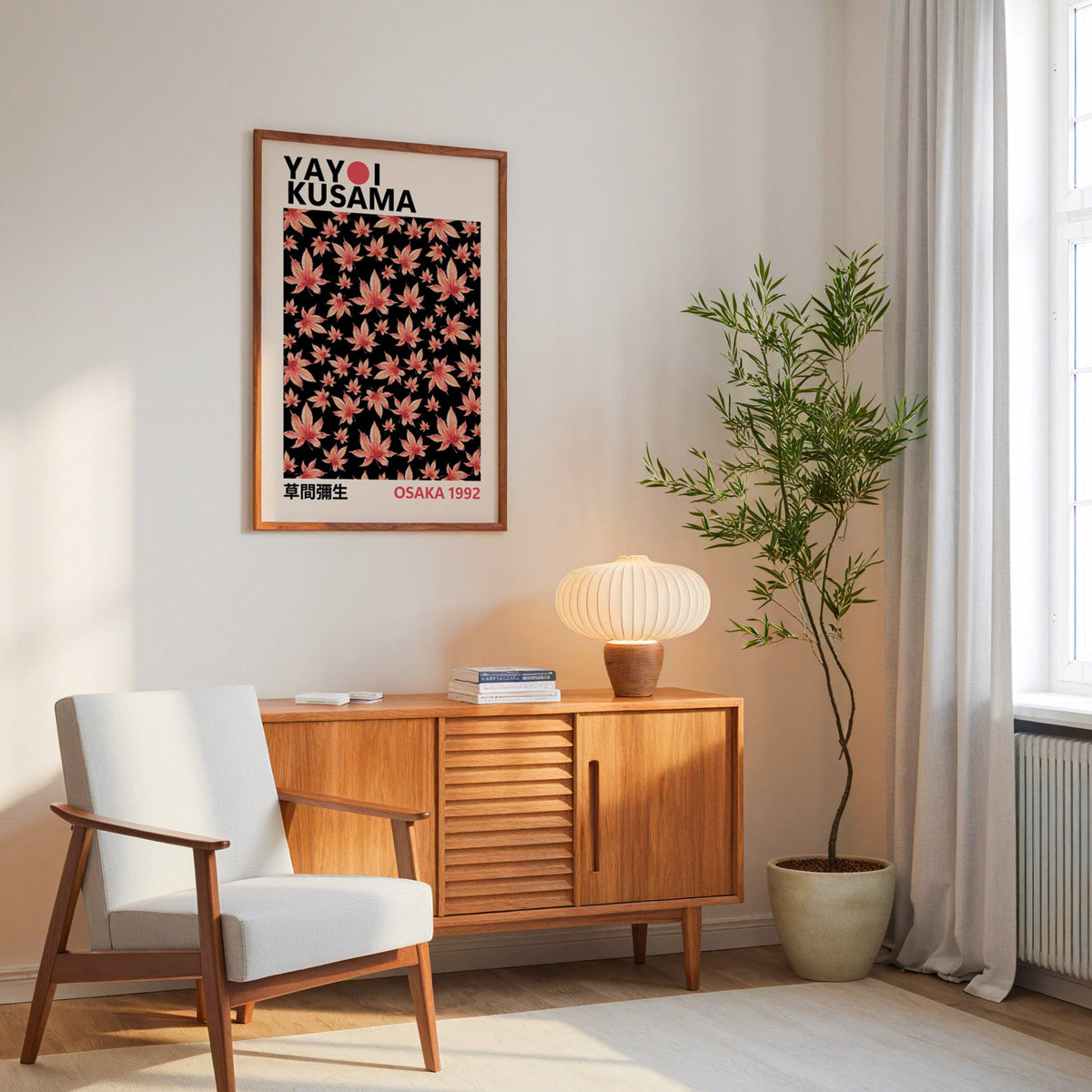 Yayoi Kusama inspired pink maple leaves on black print in an oak frame above a mid century sideboard