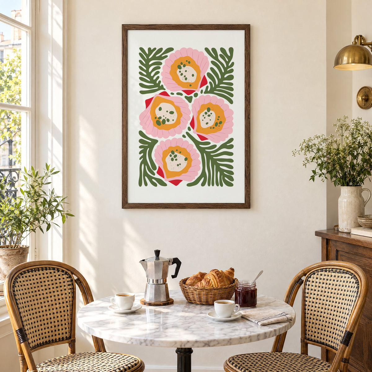 pink scallop shells green seaweed print in a walnut frame above a marble bistro table with croissants and rattan chairs