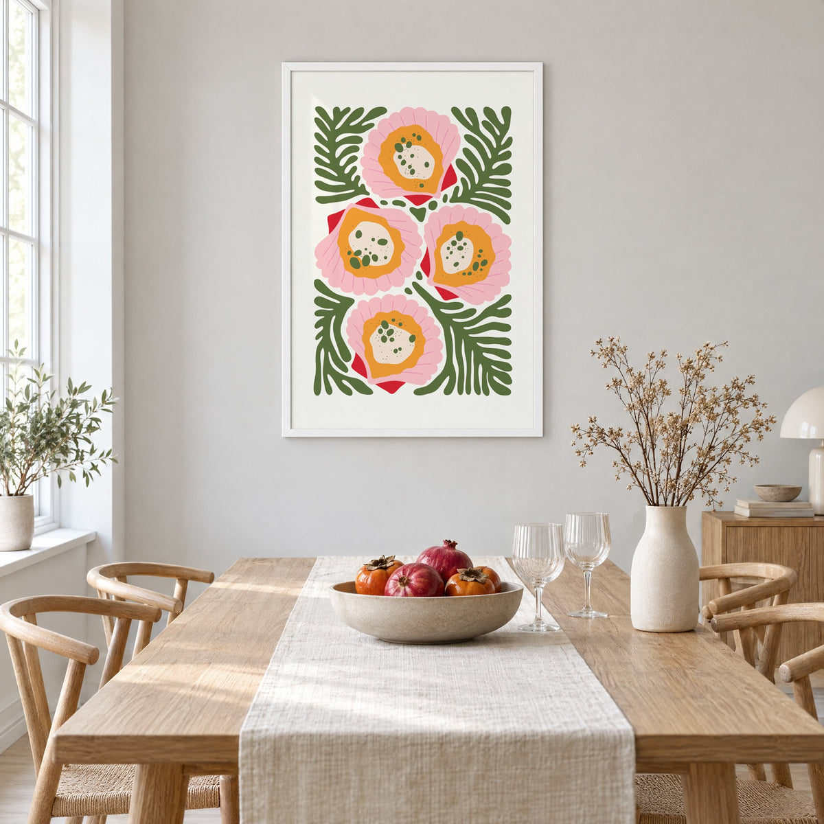 pink scallop shells green seaweed print in a white frame above a light oak dining table with a linen runner and fruit bowl