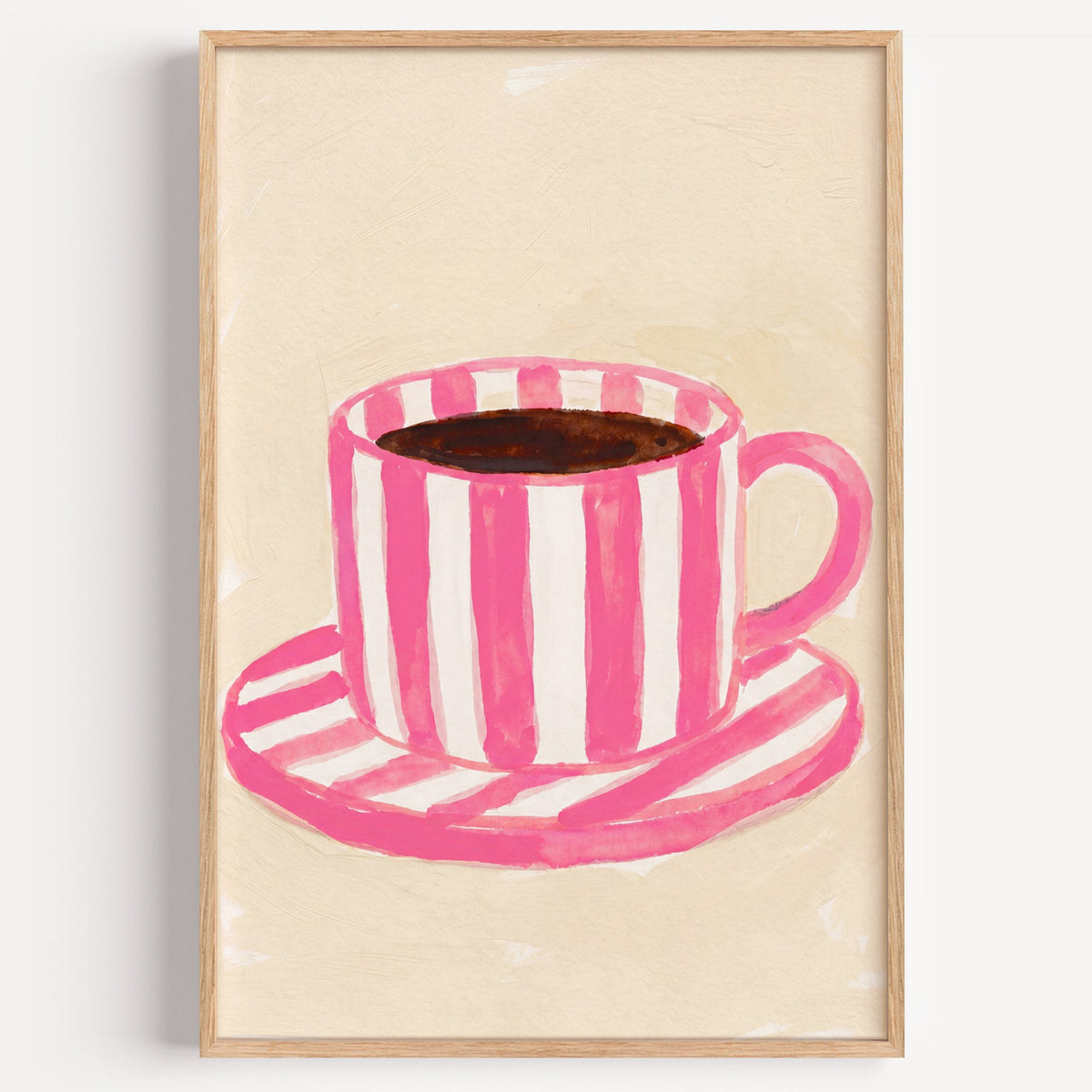 Pink striped coffee cup print in a light oak frame on a plain white wall
