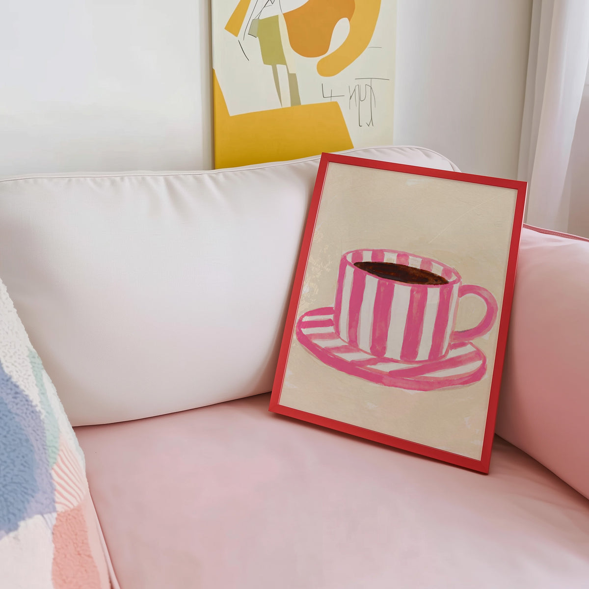 Striped mug kitchen print shown in a red frame leaning on a blush pink sofa