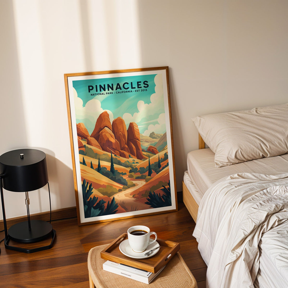 Pinnacles National Park print in an oak frame leaning on a bedroom floor beside the bed and a coffee tray