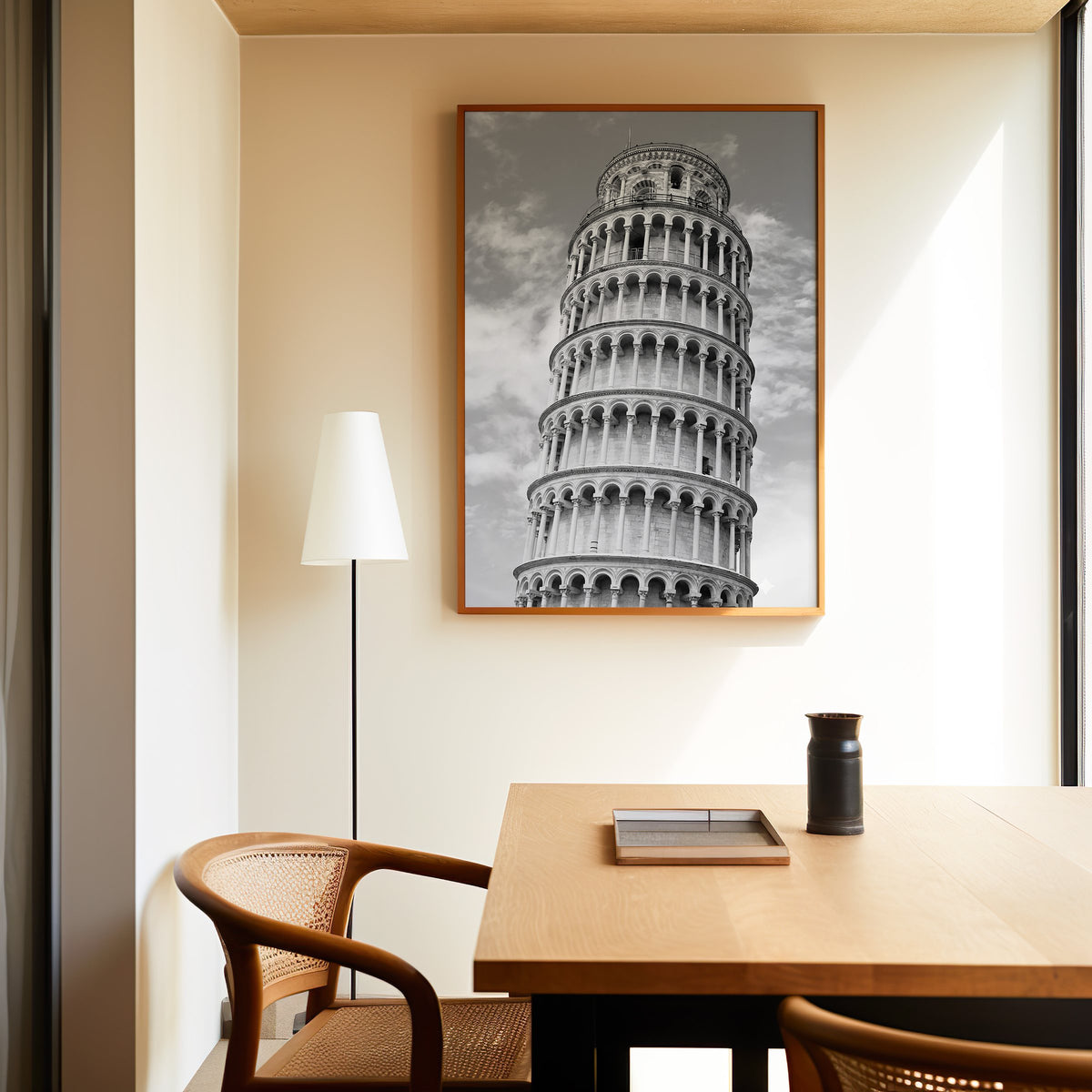 Leaning Tower of Pisa arcades from below print in an oak frame above a dining table and cane chair