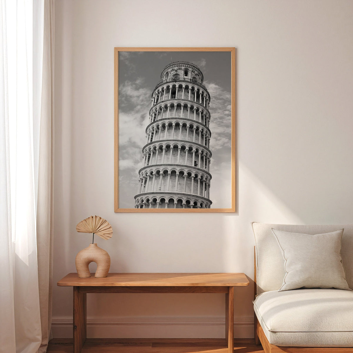 Leaning Tower of Pisa arcades from below print in an oak frame above a narrow console with an arched vase