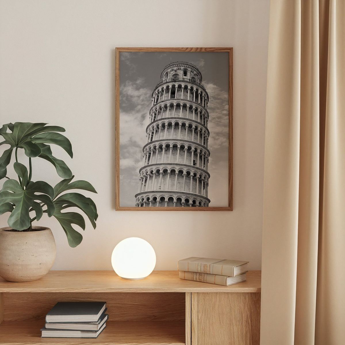Leaning Tower of Pisa arcades from below print in a walnut frame above an oak cabinet with a glowing globe lamp