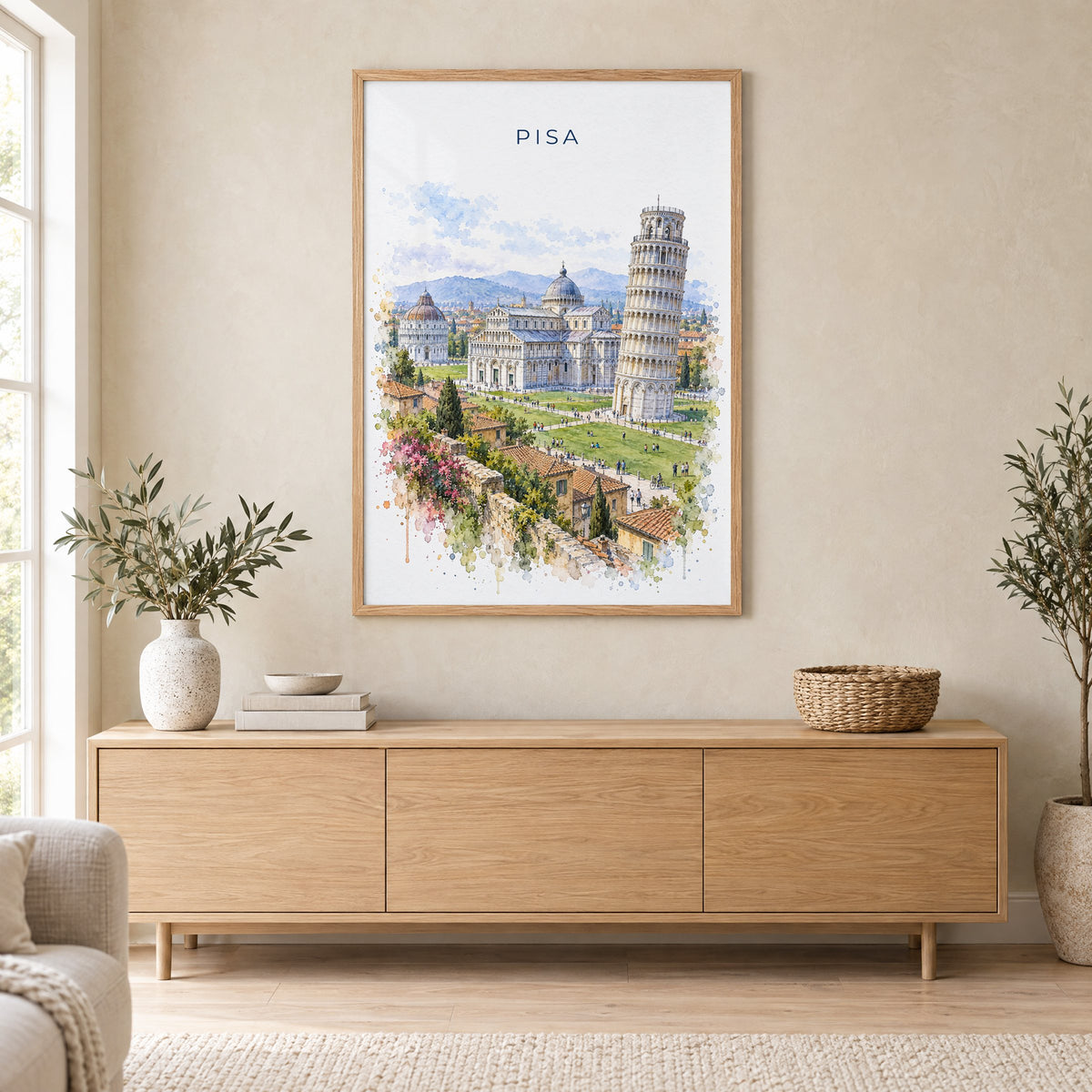 Pisa watercolor print in an oak frame above a light wood sideboard in a Scandinavian living room