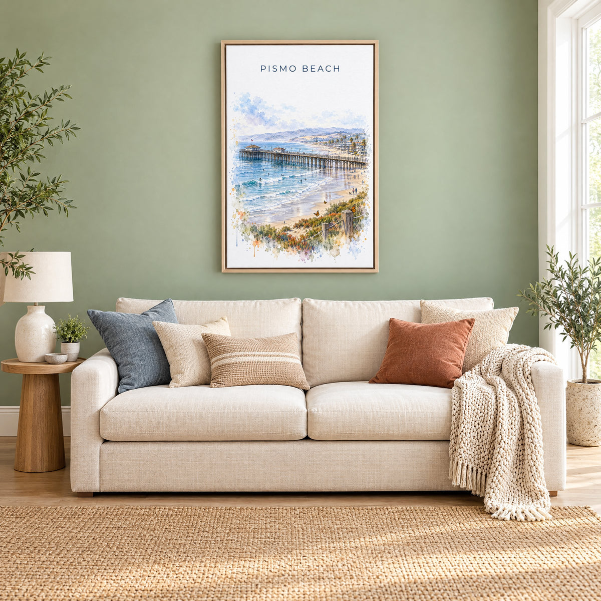 Pismo Beach watercolor print as a natural floater canvas above a cream linen sofa on a sage green wall