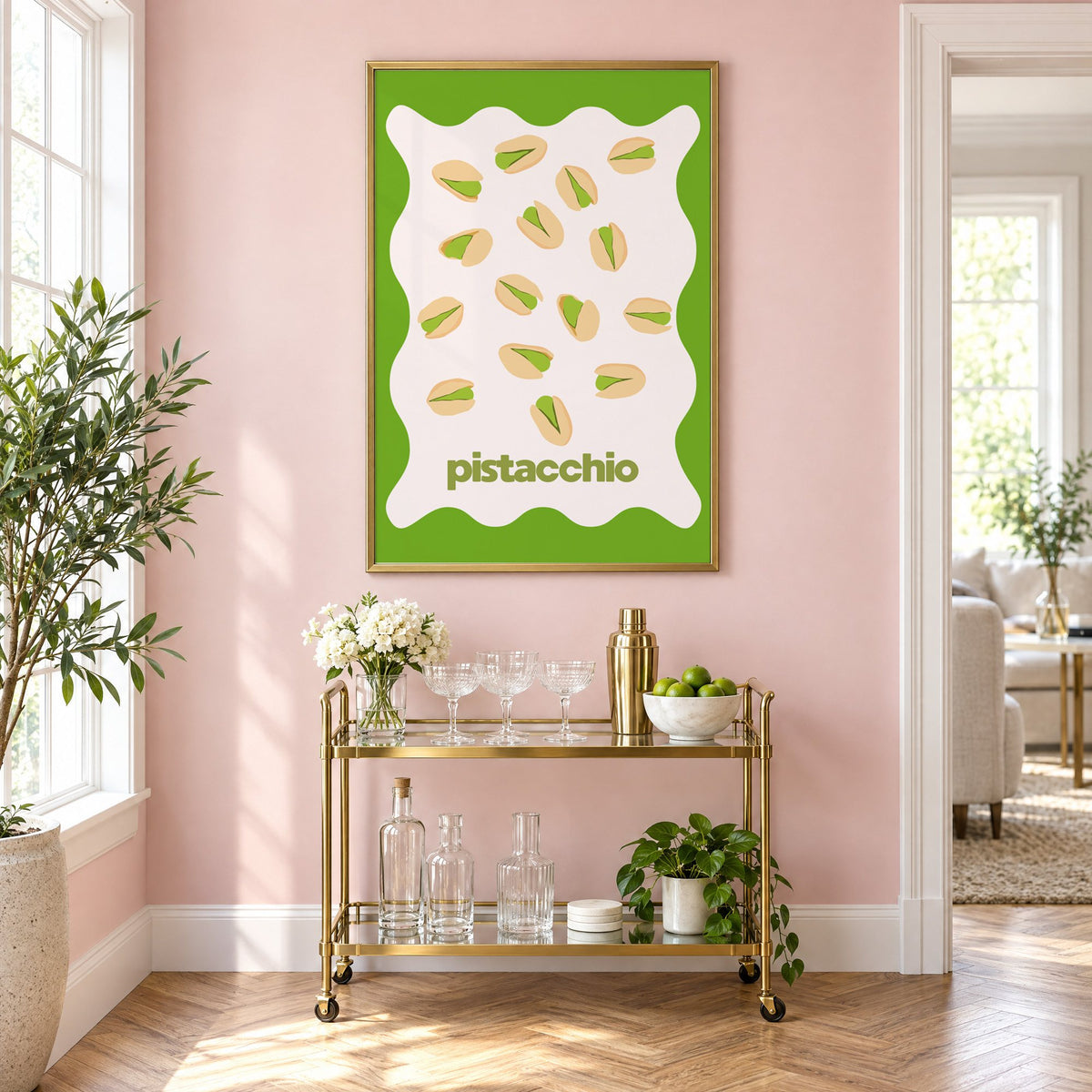 pistacchio pistachio nuts green wavy frame print in a brass frame on a blush pink wall above a gold bar cart with glassware