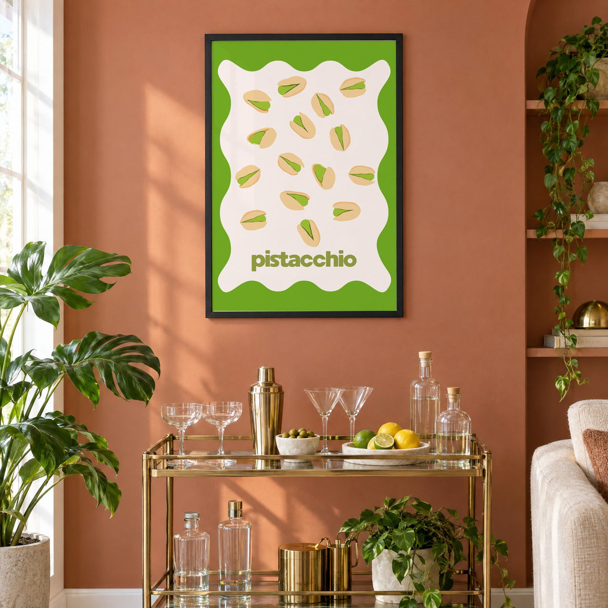 pistacchio pistachio nuts green wavy frame print in a black frame on a terracotta wall above a brass bar cart with coupes and citrus