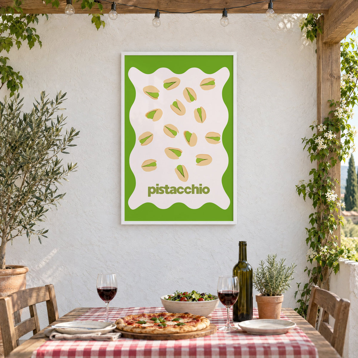 pistacchio pistachio nuts green wavy frame print in a white frame on a stucco wall above a checked-cloth table with pizza and red wine