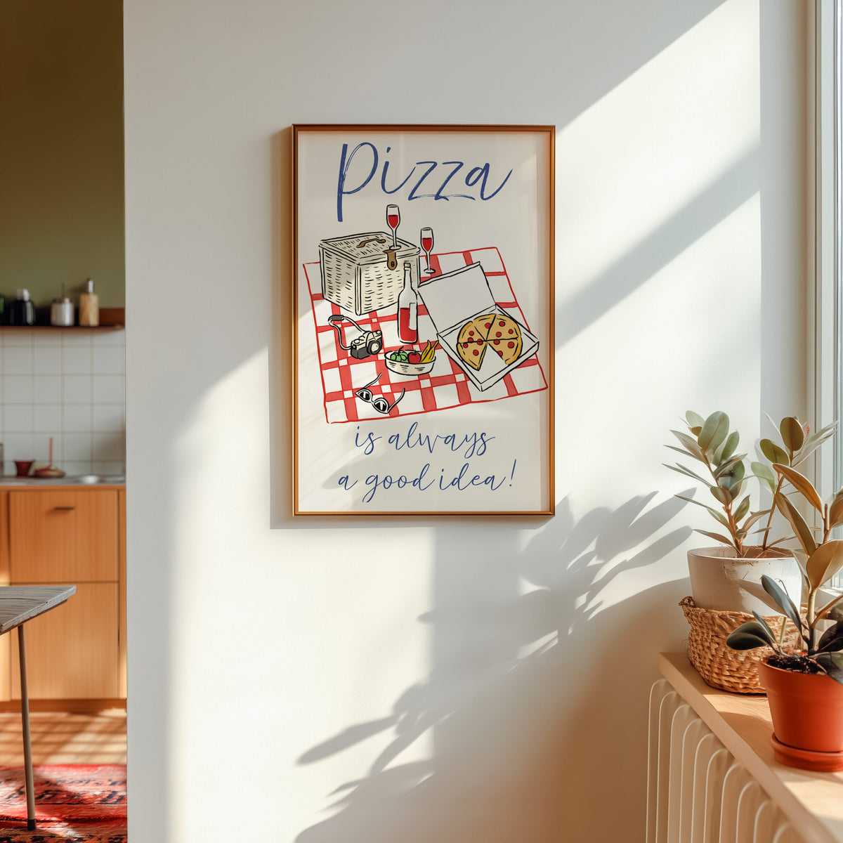 Pizza picnic print in a gold frame in sunlight with plants and a kitchen beyond