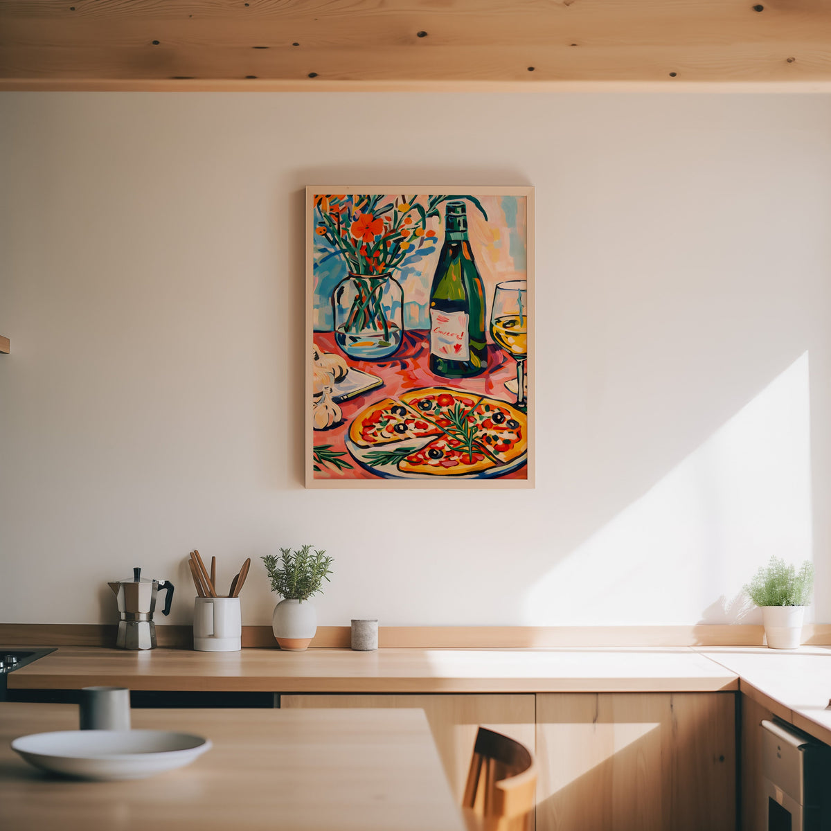 Pizza and champagne print in an oak frame above a wood counter with a moka pot