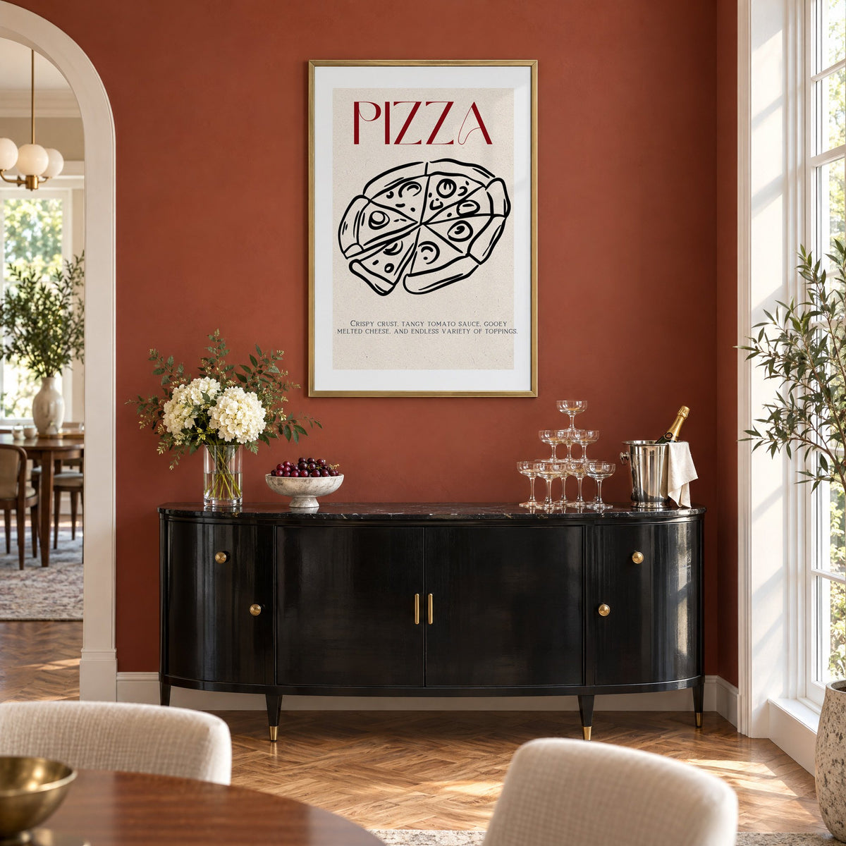 PIZZA red title line-art pizza print in a brass frame on a terracotta wall above a black buffet with a champagne tower