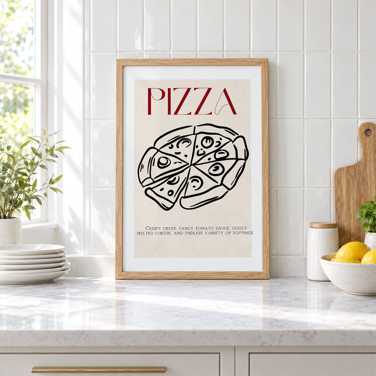 PIZZA red title line-art pizza print in an oak frame leaning on a marble counter by white tiles and lemons