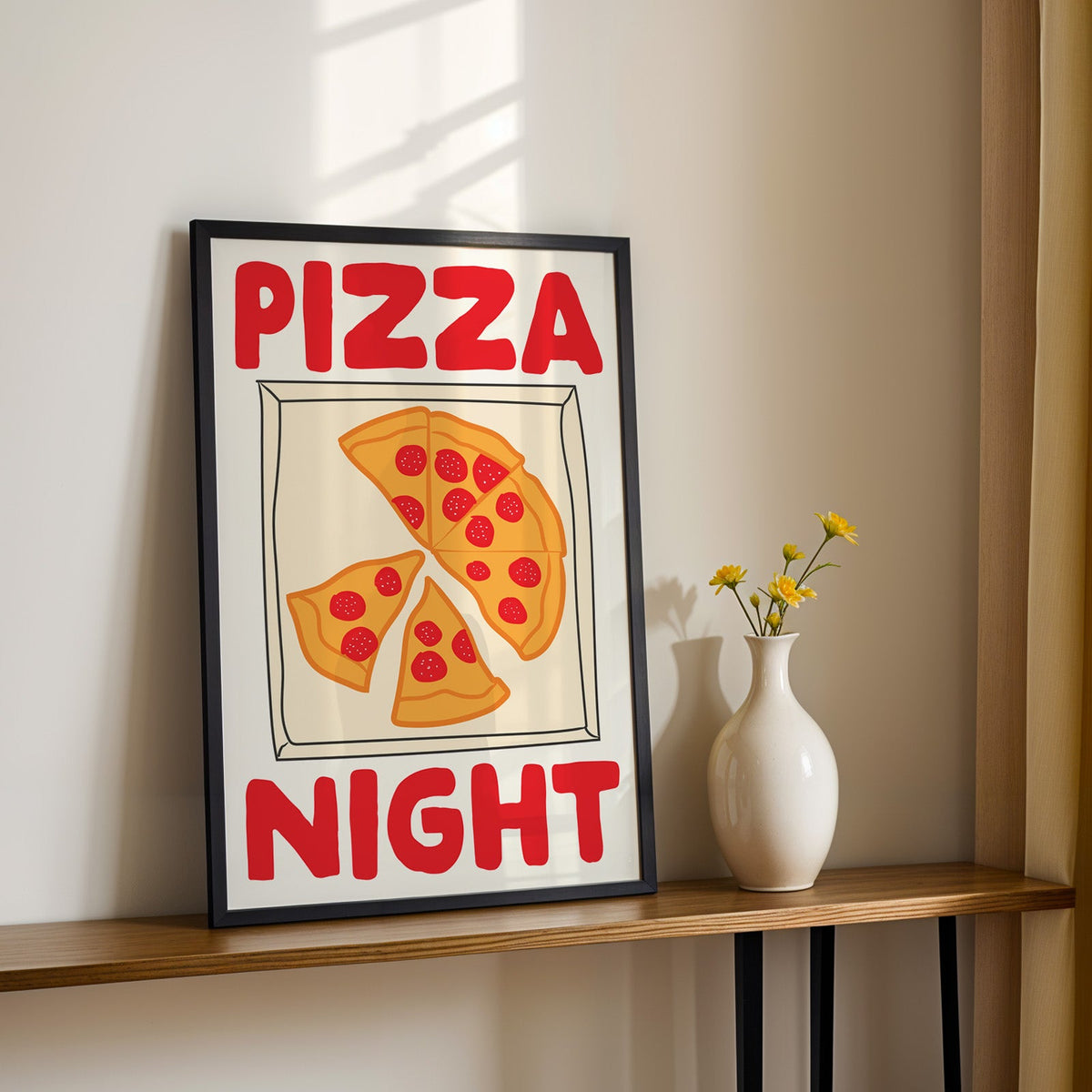 Pizza night pepperoni box print in a black frame on a console table with daisies