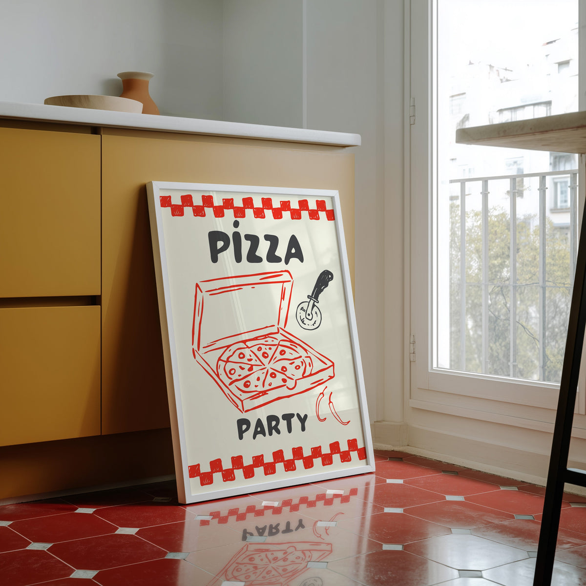 Pizza Party print in a white frame against yellow cabinets on a red tiled floor