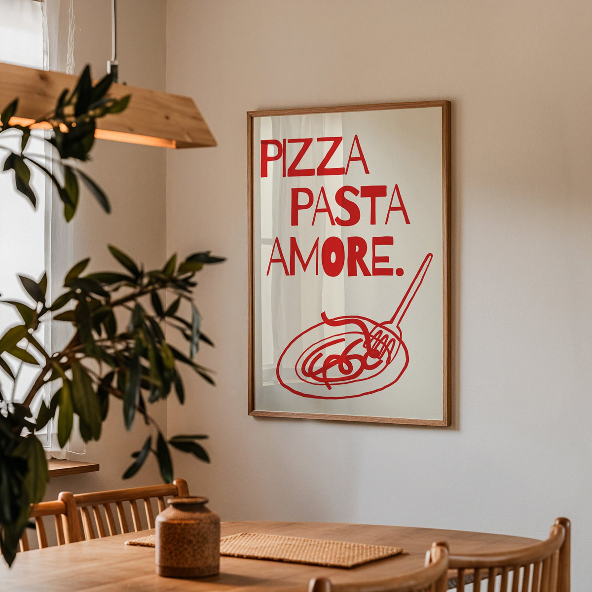 Pizza Pasta Amore print in a walnut frame above a dining table with olive branches