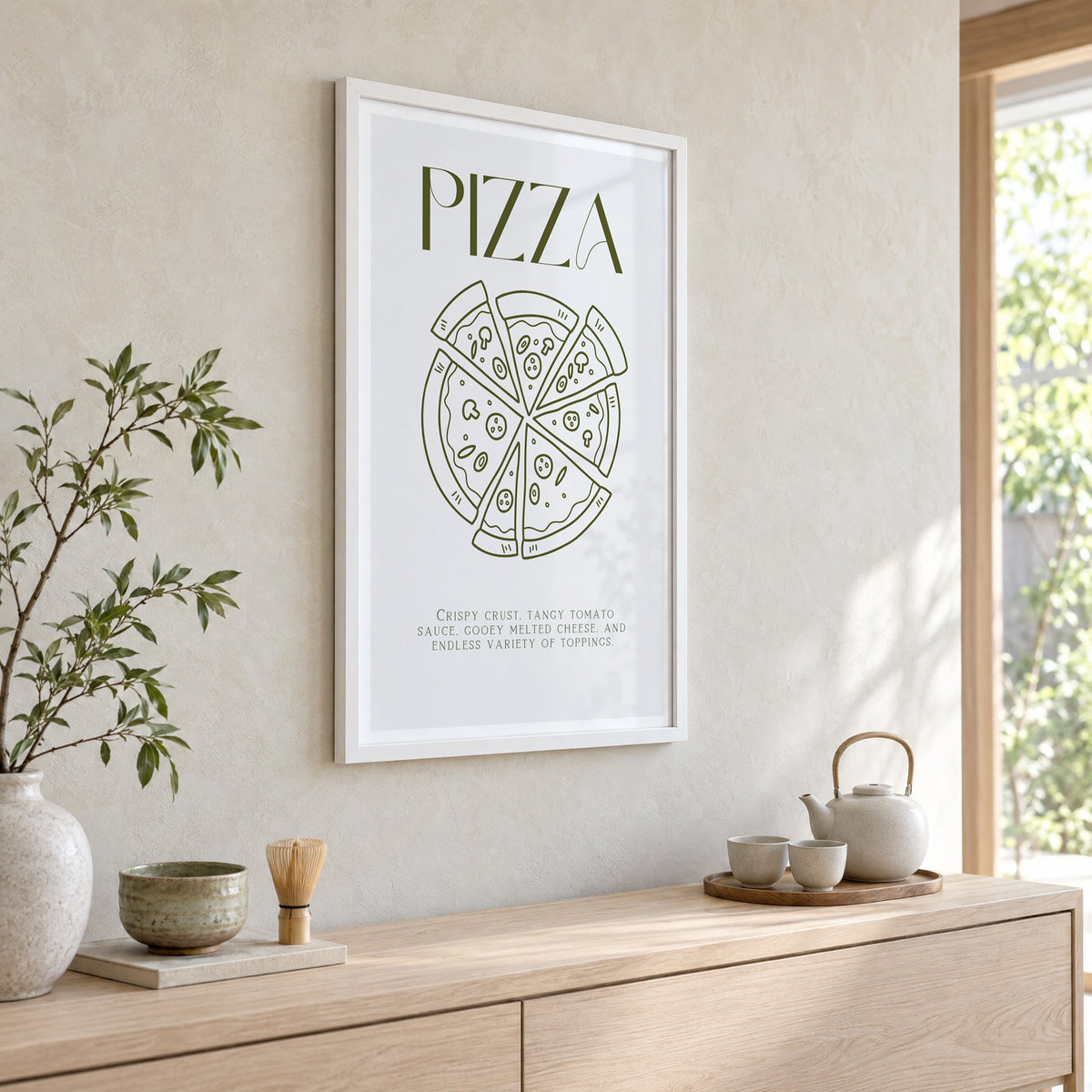 PIZZA olive line art print in a white frame above a pale wood console with a matcha tea set