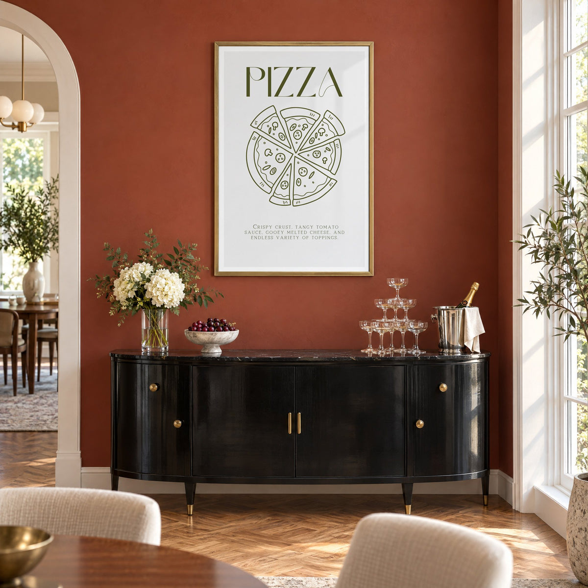 PIZZA olive line art print in a brass frame on a terracotta wall above a black buffet with a champagne tower