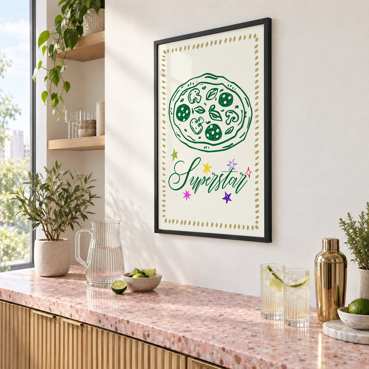 Superstar green pizza and stars print in a black frame above a pink terrazzo cocktail counter with limes, seen at an angle