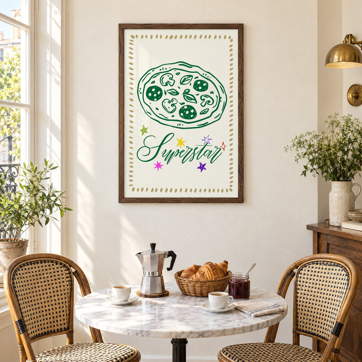 Superstar green pizza and stars print in a walnut frame above a marble bistro table with croissants and rattan chairs
