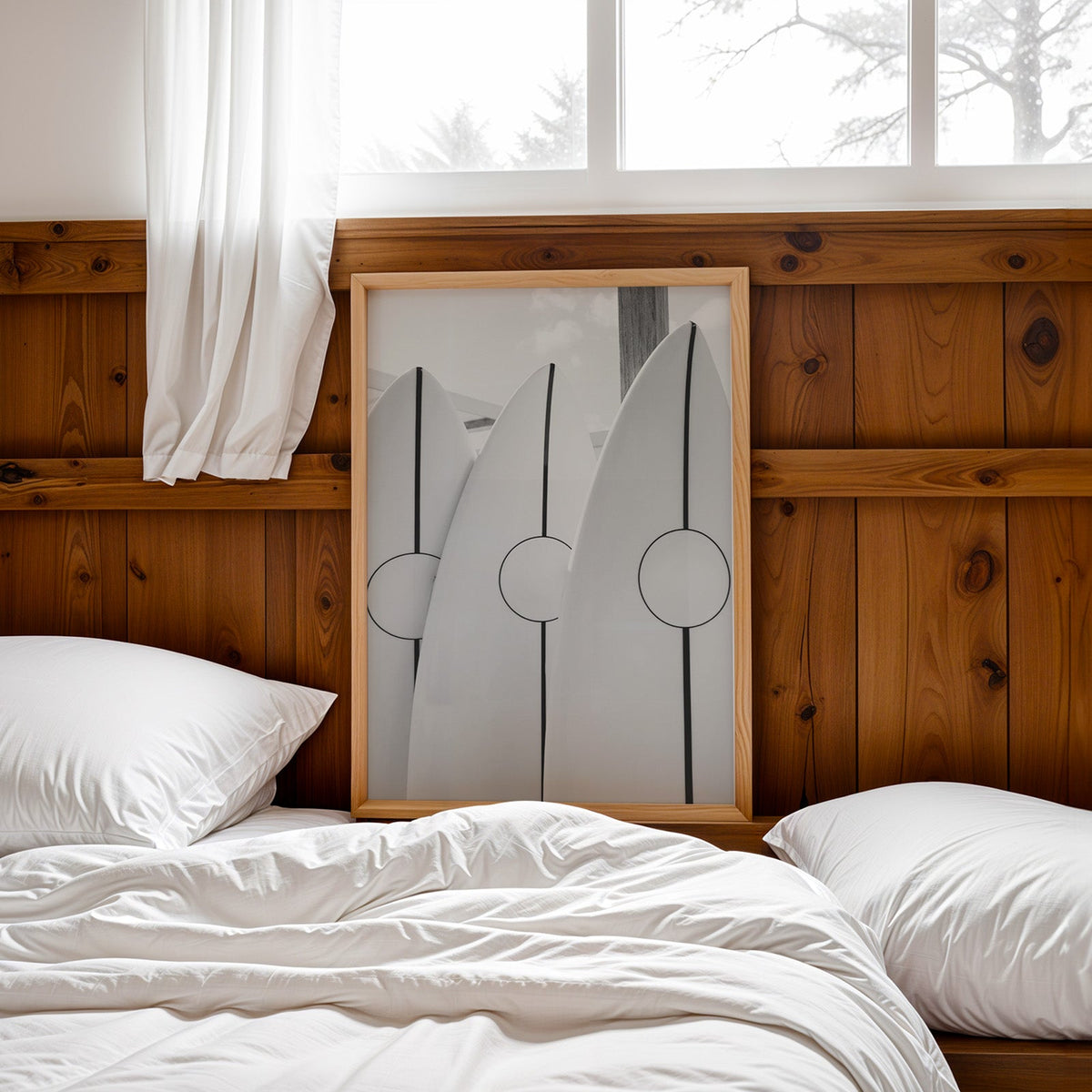 Three white surfboards with black stripes print in a pine frame leaning on a wood headboard over white bedding