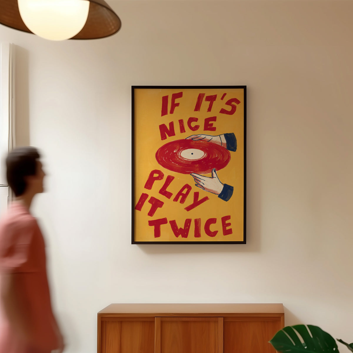 Retro music quote print in a black frame in a hallway under a rattan pendant