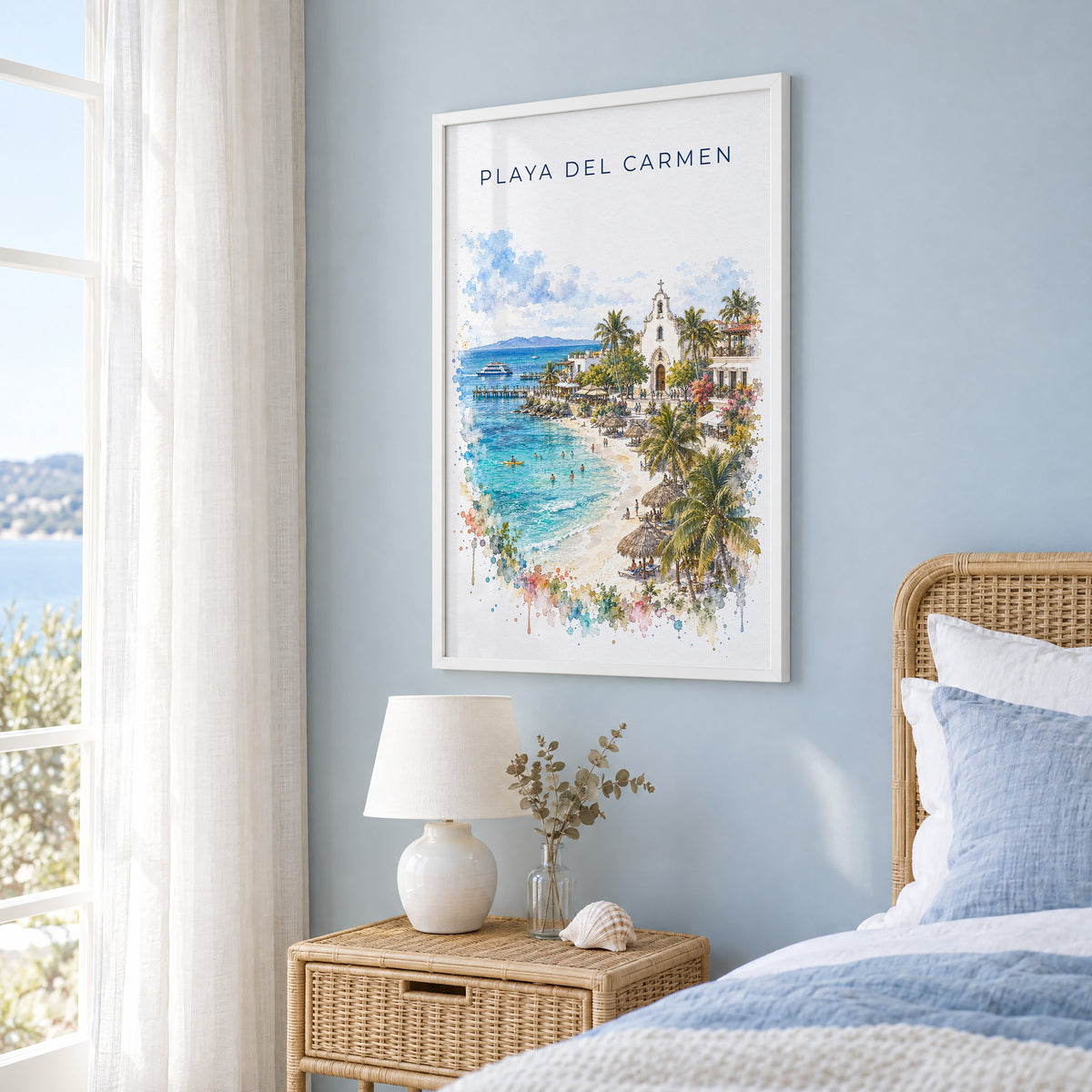 Playa del Carmen watercolor print in a white frame on a pale blue wall beside a rattan bed in a coastal bedroom