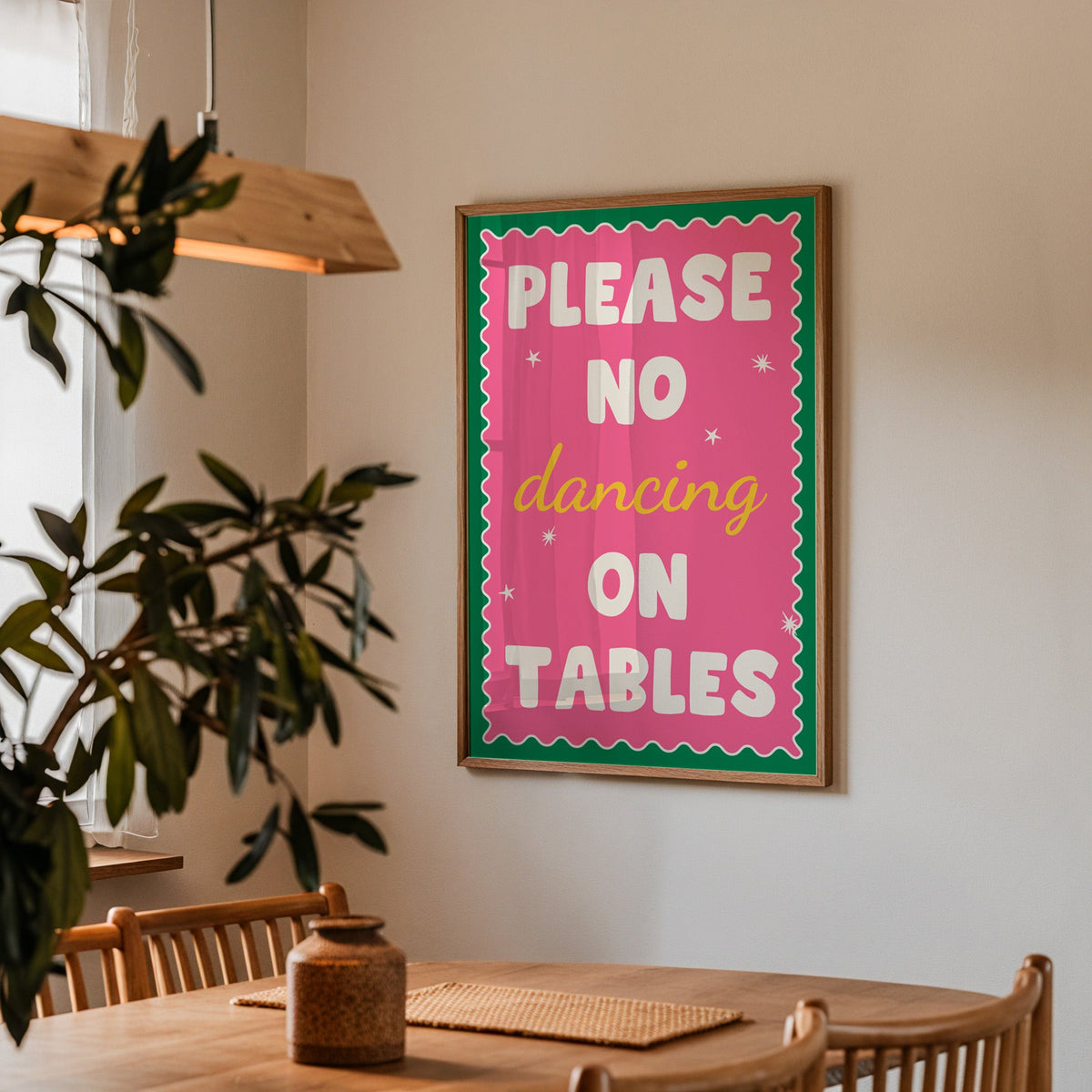 Please no dancing on tables print in a walnut frame above a table beside an olive tree