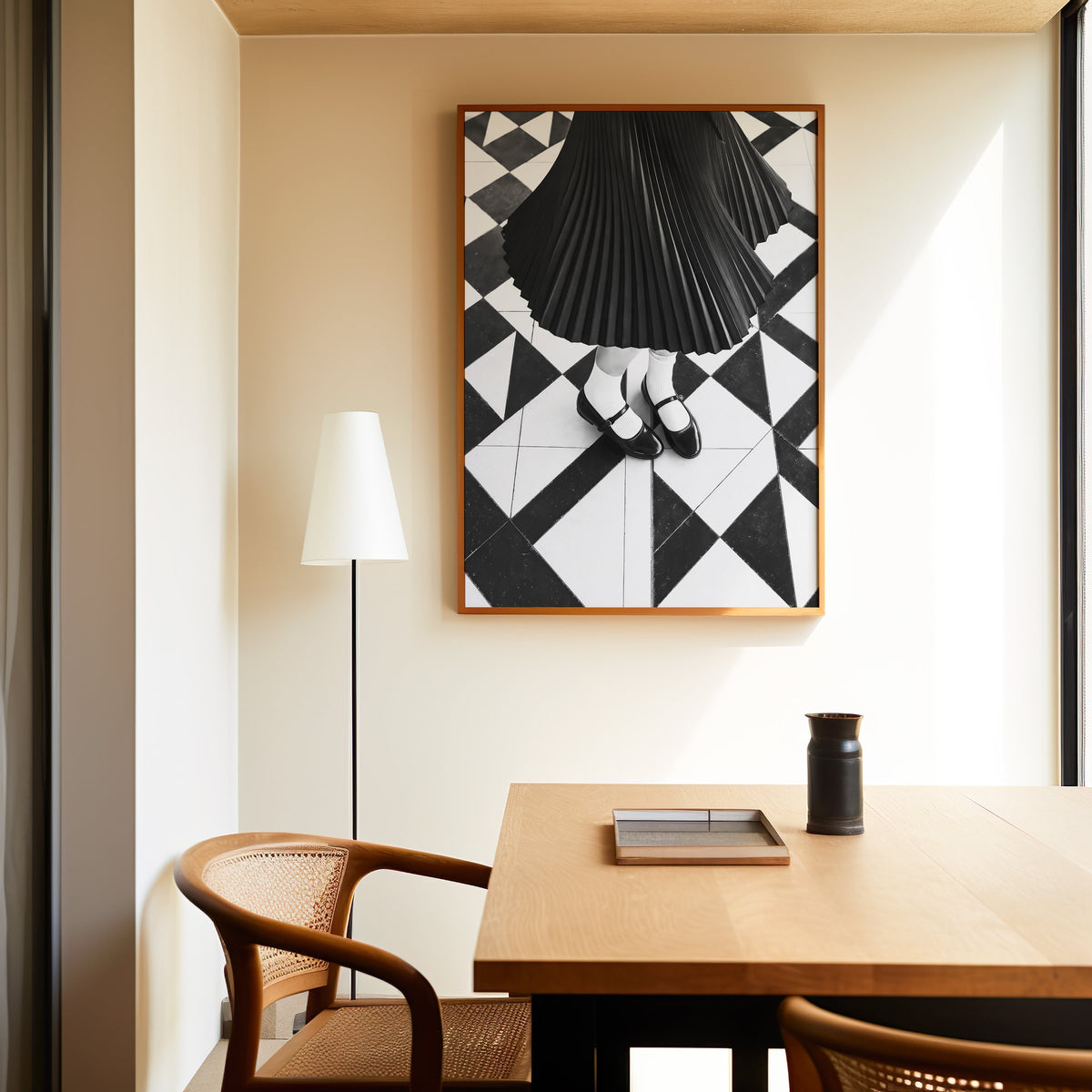 Pleated skirt and strap shoes on geometric tile print in an oak frame above a dining table and cane chair