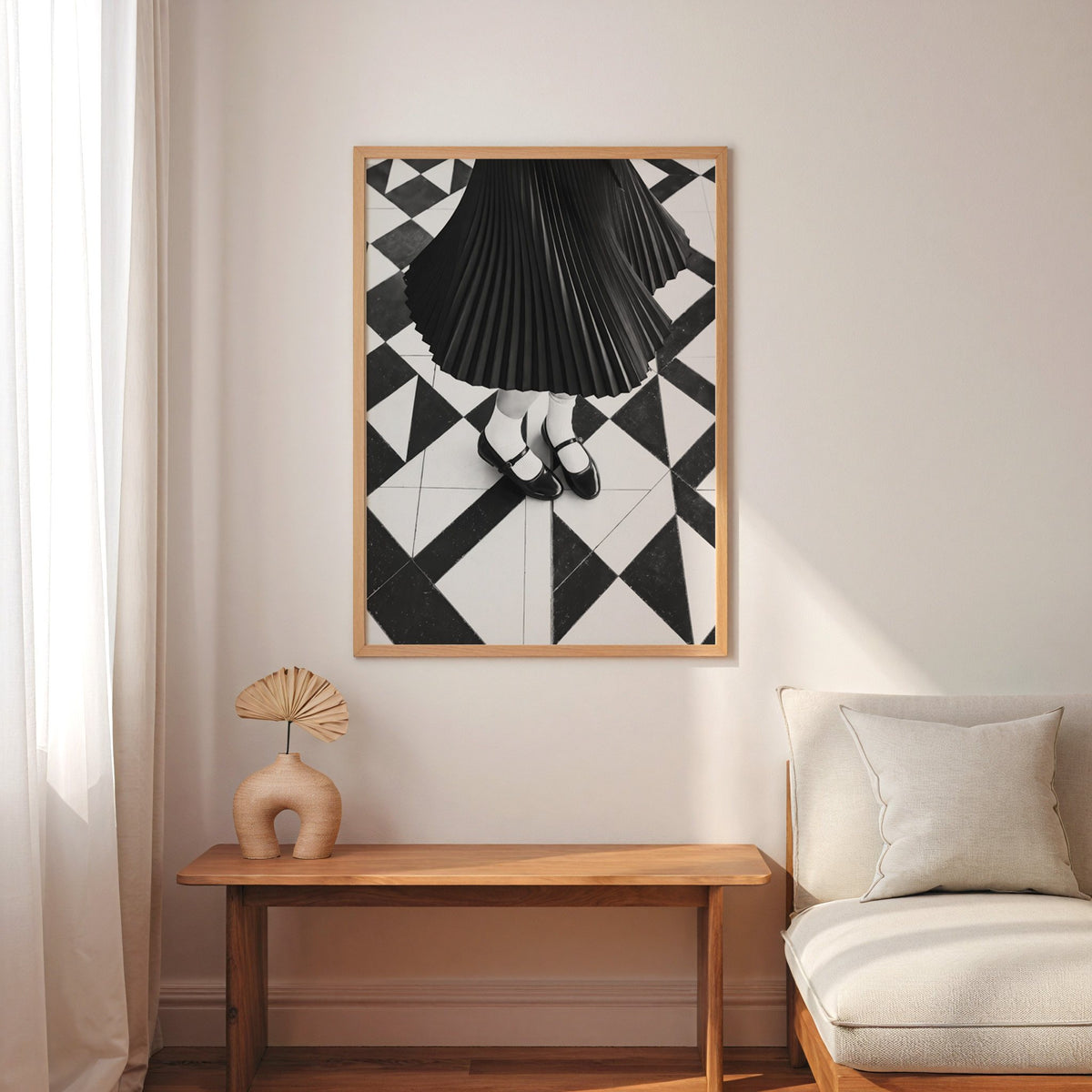 Pleated skirt and strap shoes on geometric tile print in an oak frame above a narrow console with an arched vase