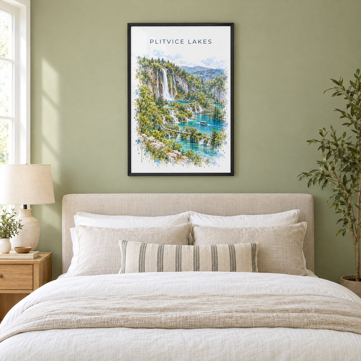 Plitvice Lakes watercolor print in a black frame above an upholstered headboard in a sage green bedroom
