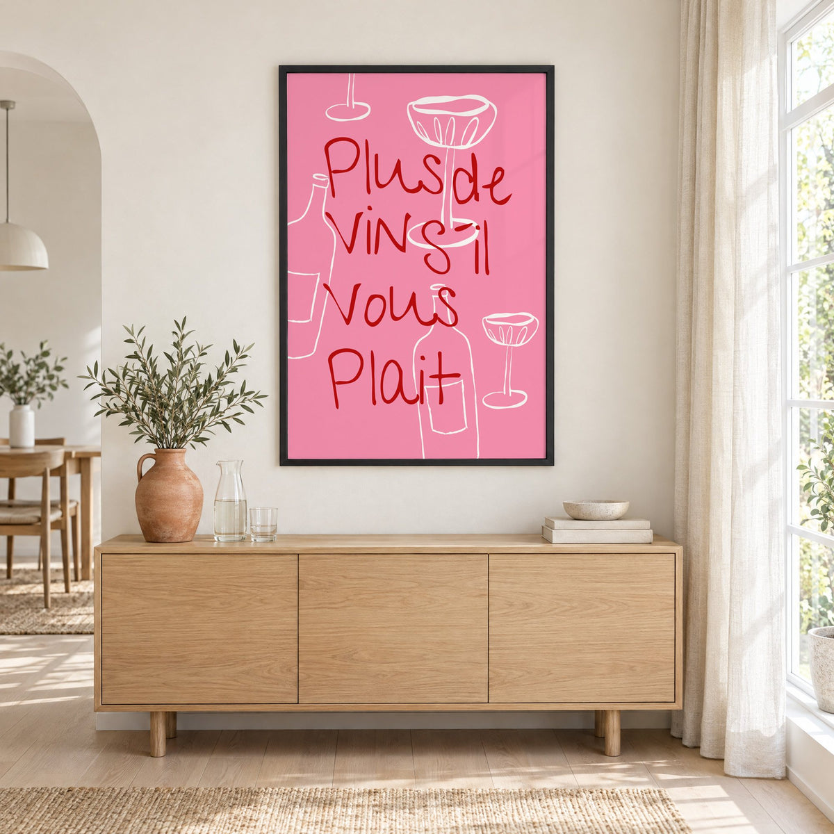 Plus de Vin handwritten pink print in a black frame above an oak sideboard with a terracotta vase of olive branches