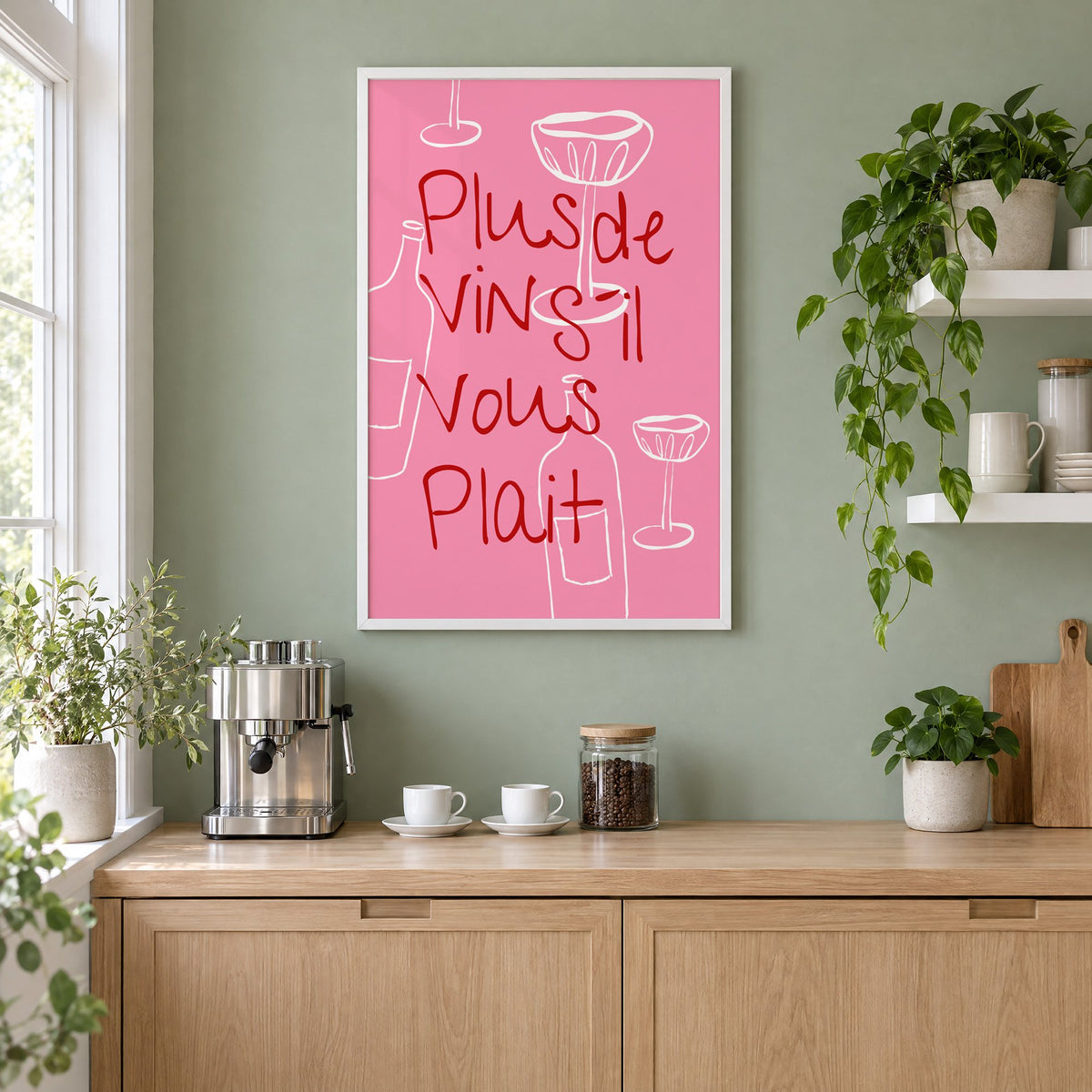Plus de Vin handwritten pink print in a white frame on a sage green coffee nook wall above an espresso machine